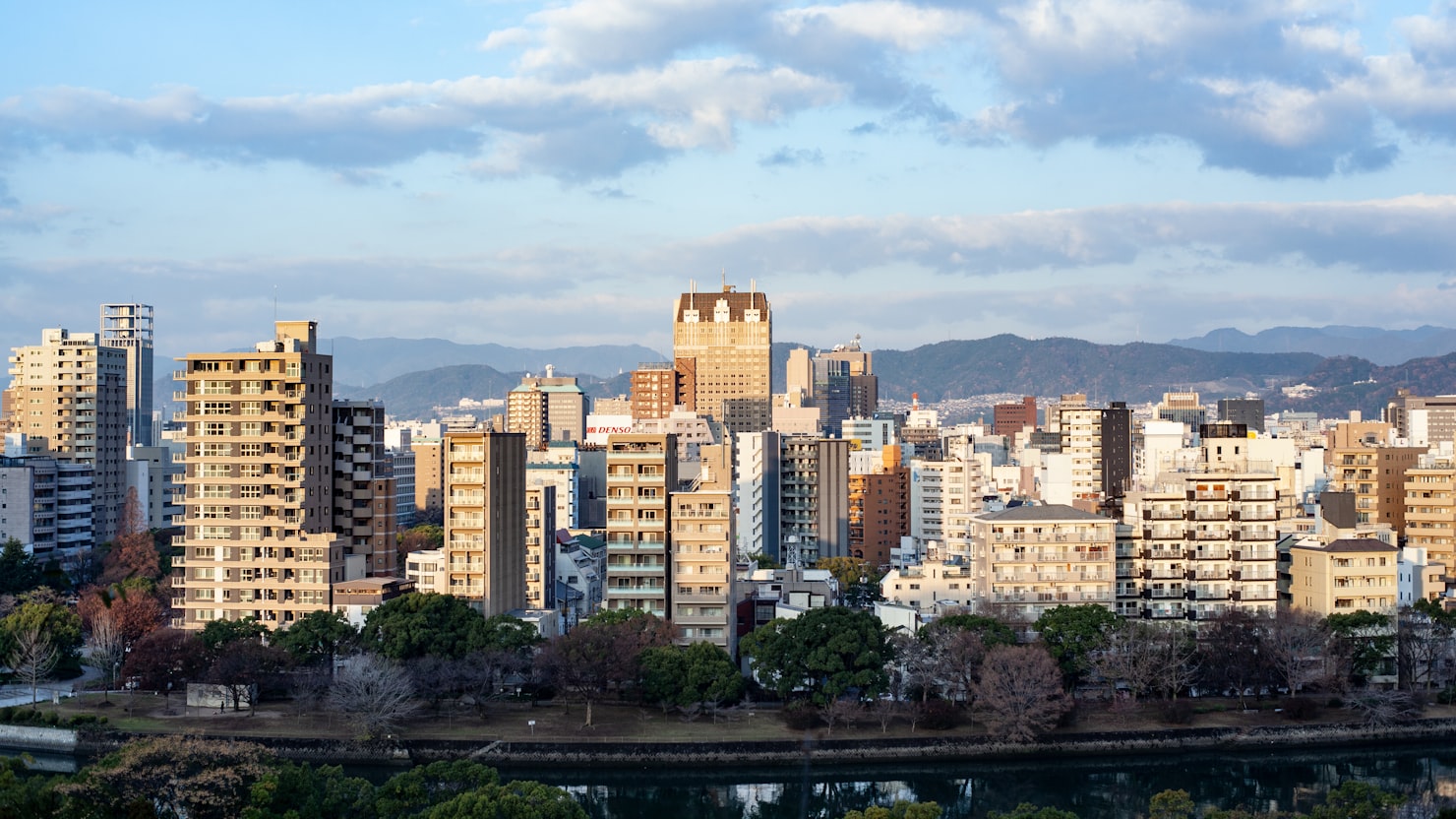広島の街並みとリモートワークで働くエンジニアのイメージ