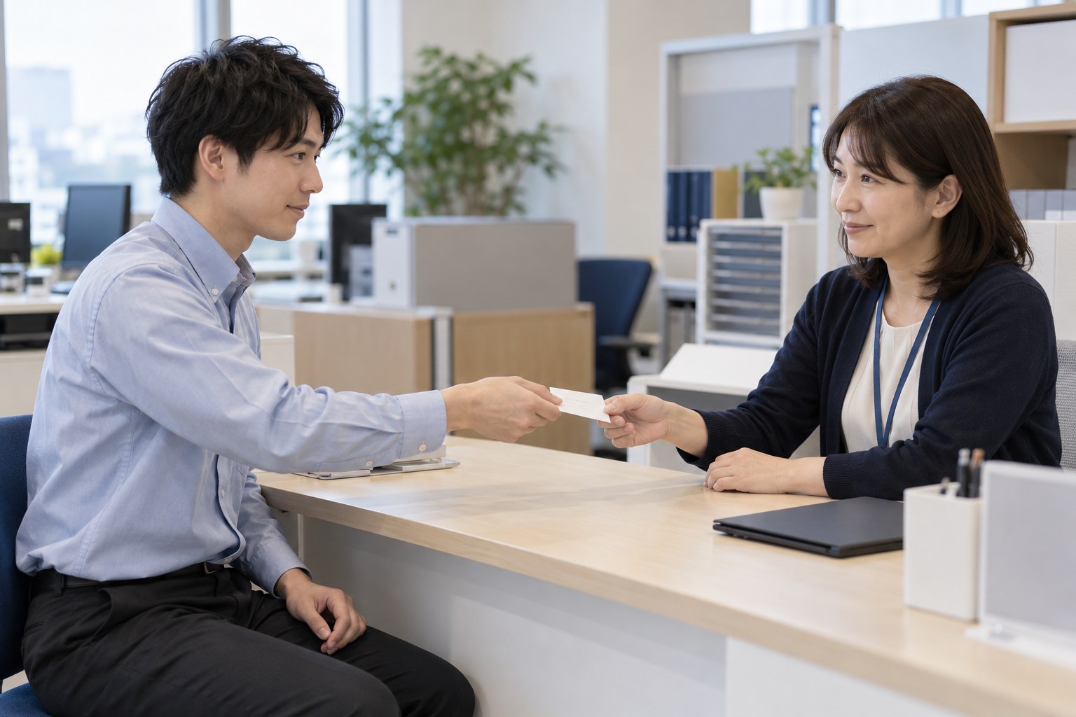 午後の新しい会社の人事の席で、番号のメモを人事担当者に渡す入社した社員